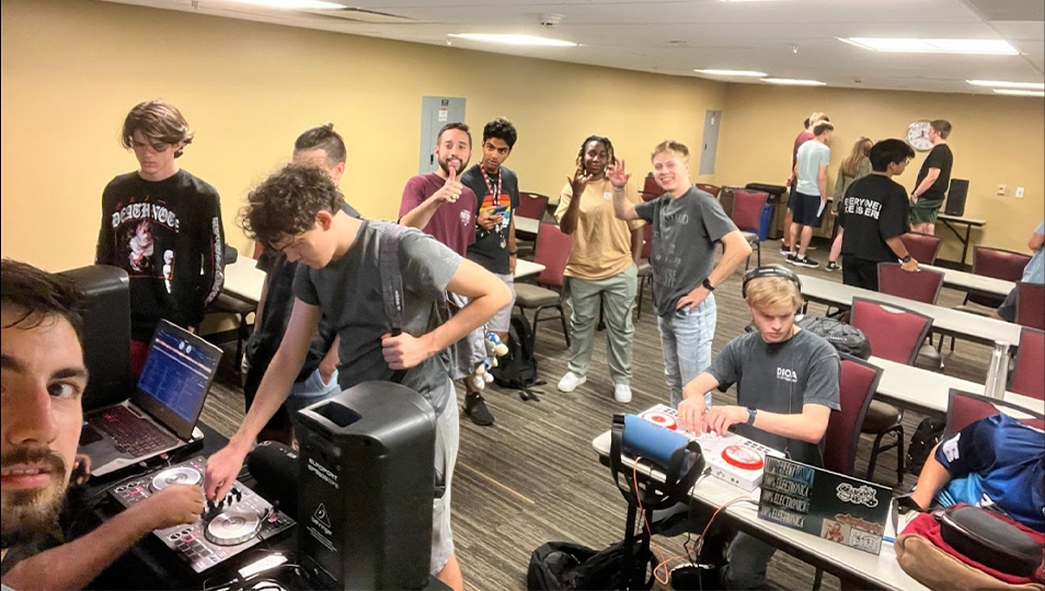 an image of people in a room with DJ equipment